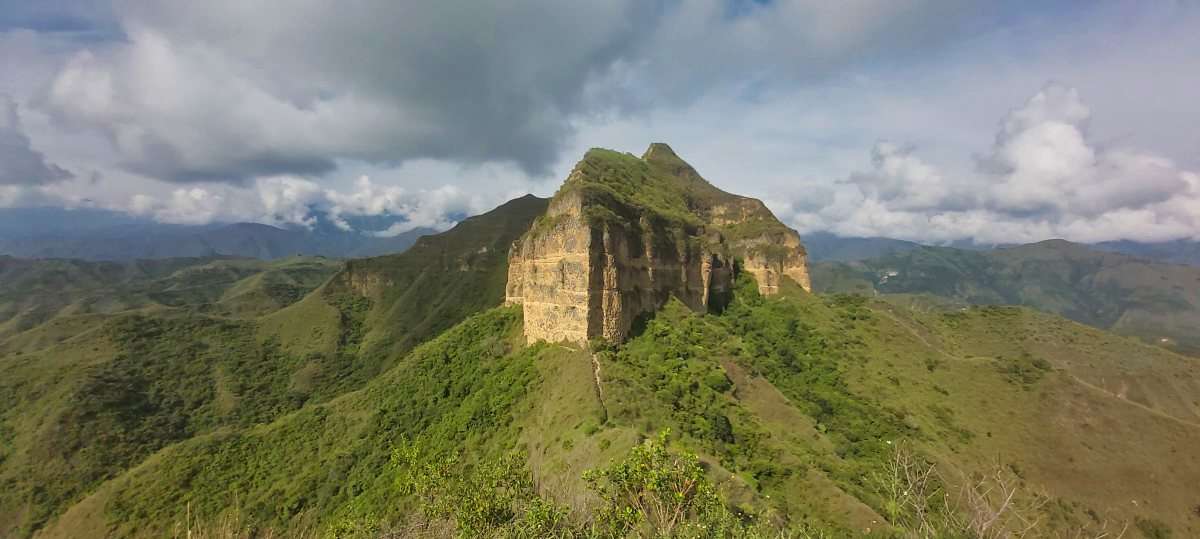 a large straight faced rock formation on a mountain